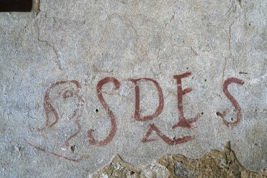 Antique graffito with SDES inscription and stylized face inside the House of Thiasus
