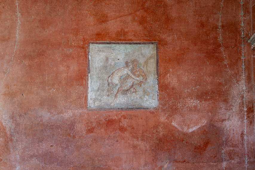 Erotic fresco on red background in the House of the Red Walls in Pompeii
