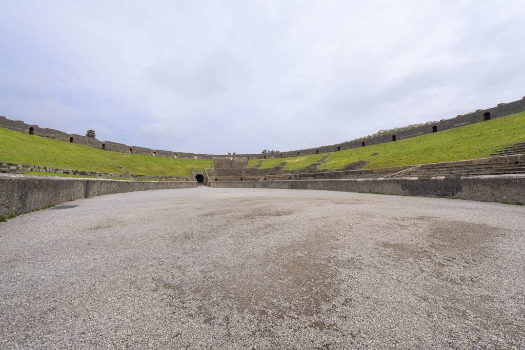 Overview of Pompeii amphitheater with cloudy skies.