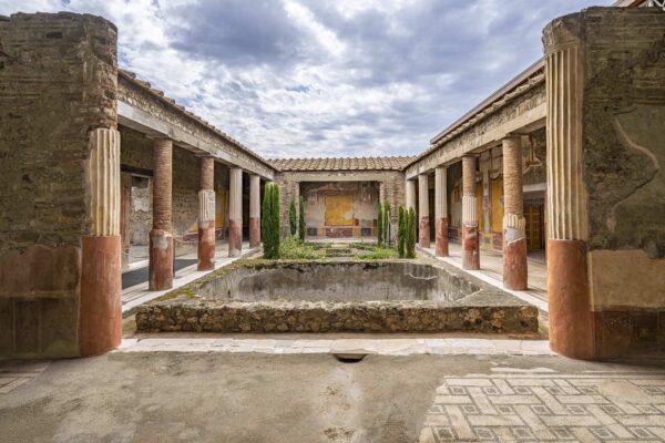 Peristyle of the House of Dioscuri in Pompeii with columns and frescoes