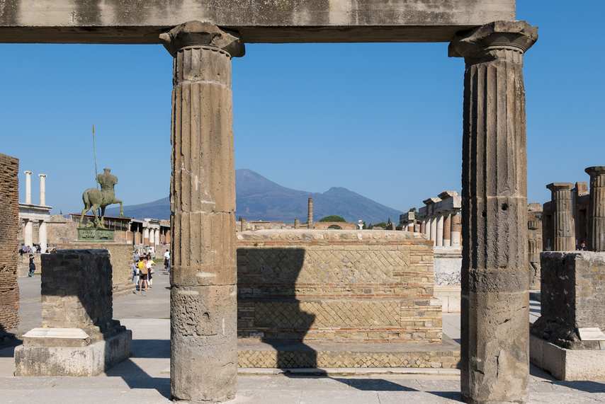 Ancient columns from the Forum of Pompeii with a view of Vesuvius in the background