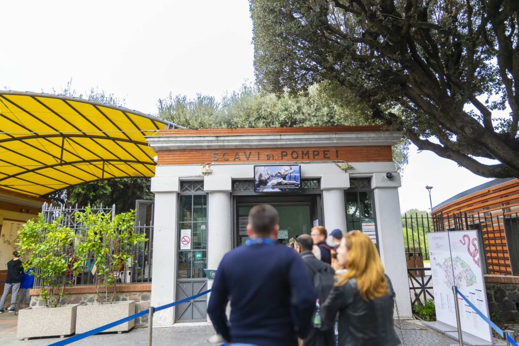Amphitheater entrance to Pompeii ruins with tourists in line