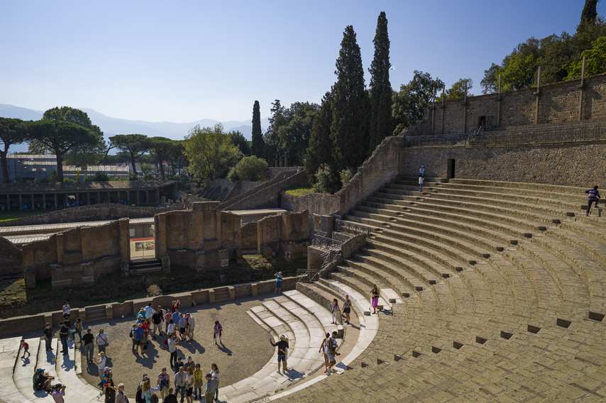 Diagonal view of the Large Theatre of Pompeii with stalls and vegetation in the background